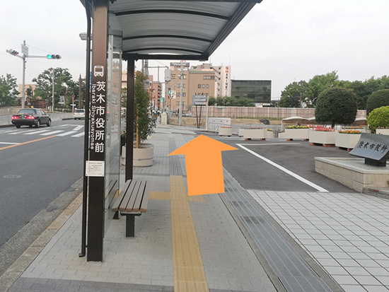 ④後はまっすぐ進むのみです。駅前通り・茨木市役所前のバス停を通過します。市役所を過ぎればあと半分です。